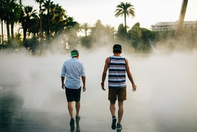 街头摄影的两个男人走在前面的喷泉
